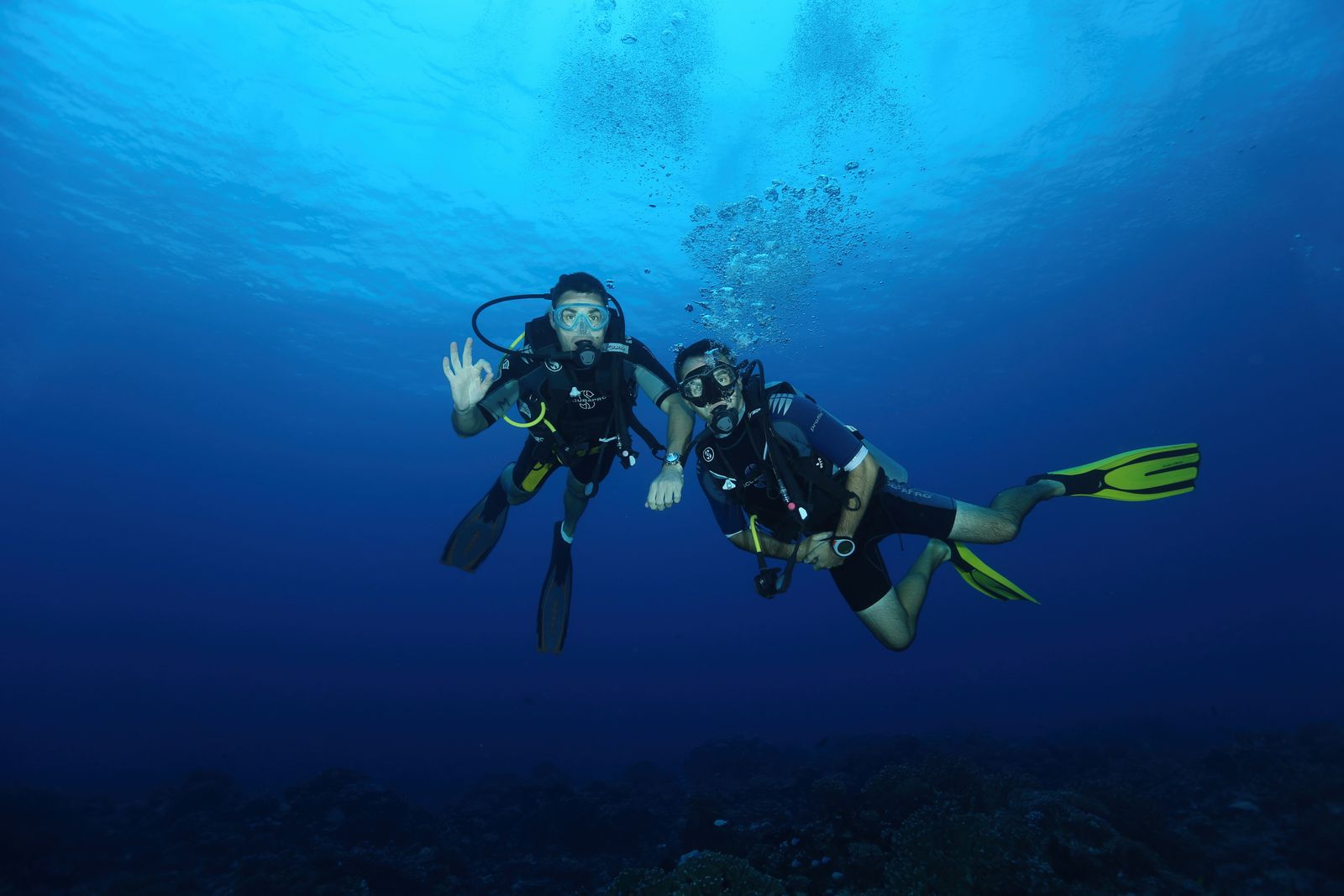 Diver descending through cold, clear water
