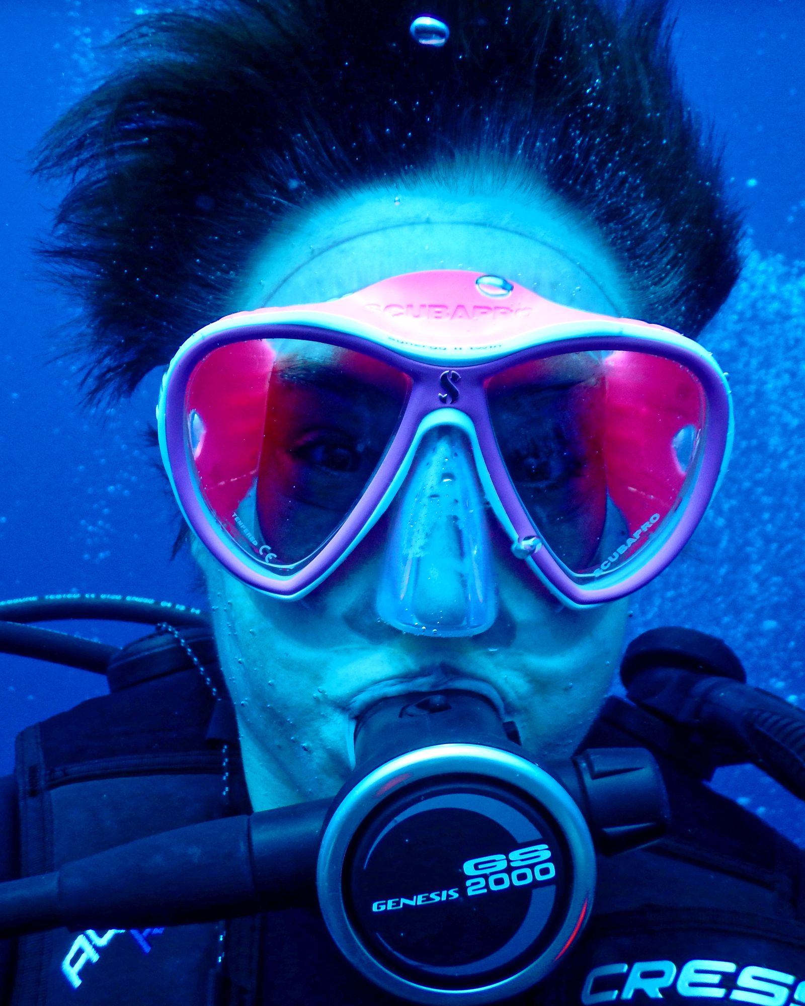 Instructor checking a student's mask before a dive
